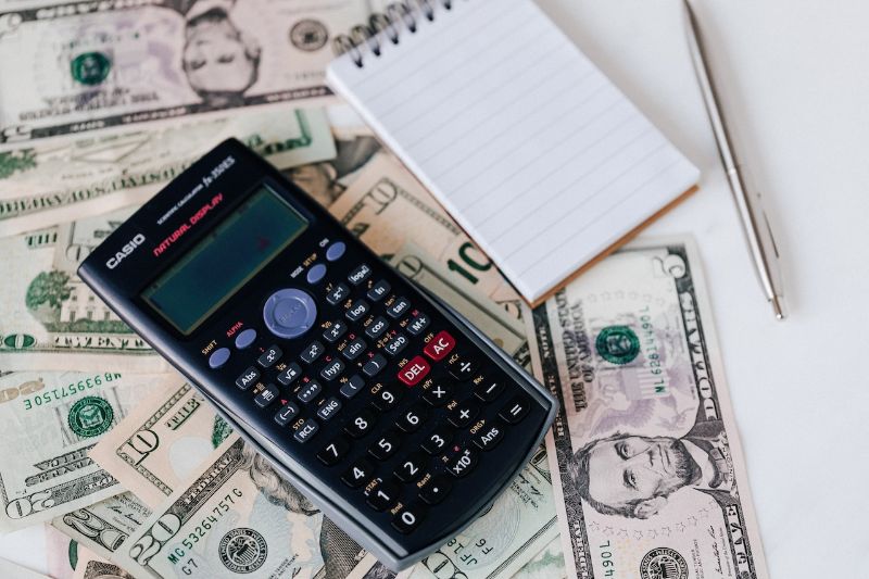 Close Up image of money, calculator, and note pad